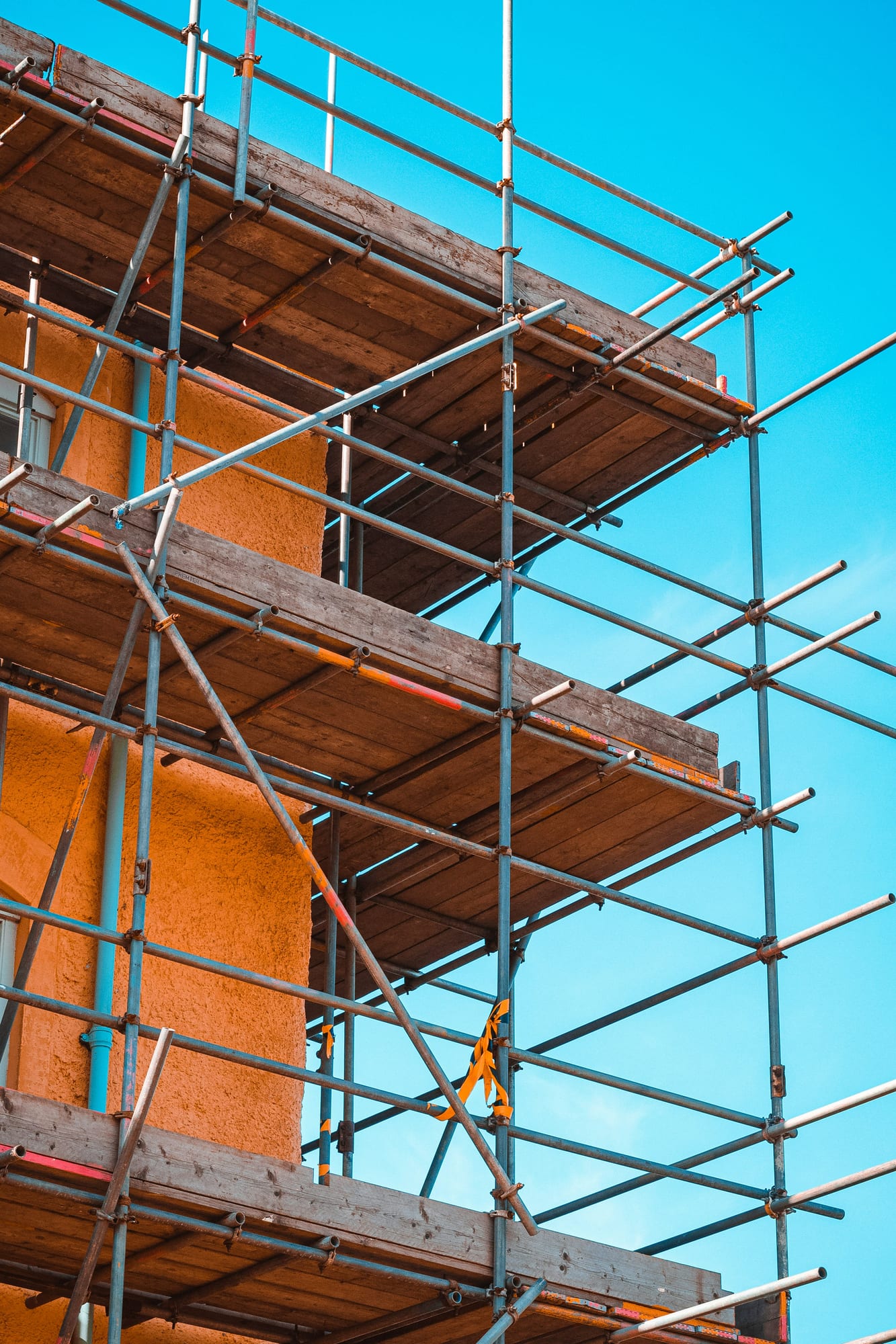 Nahaufnahme der Plattform mit Holzbohlen und Sicherungsgurten, die der Gerüstbauer gesichert hat