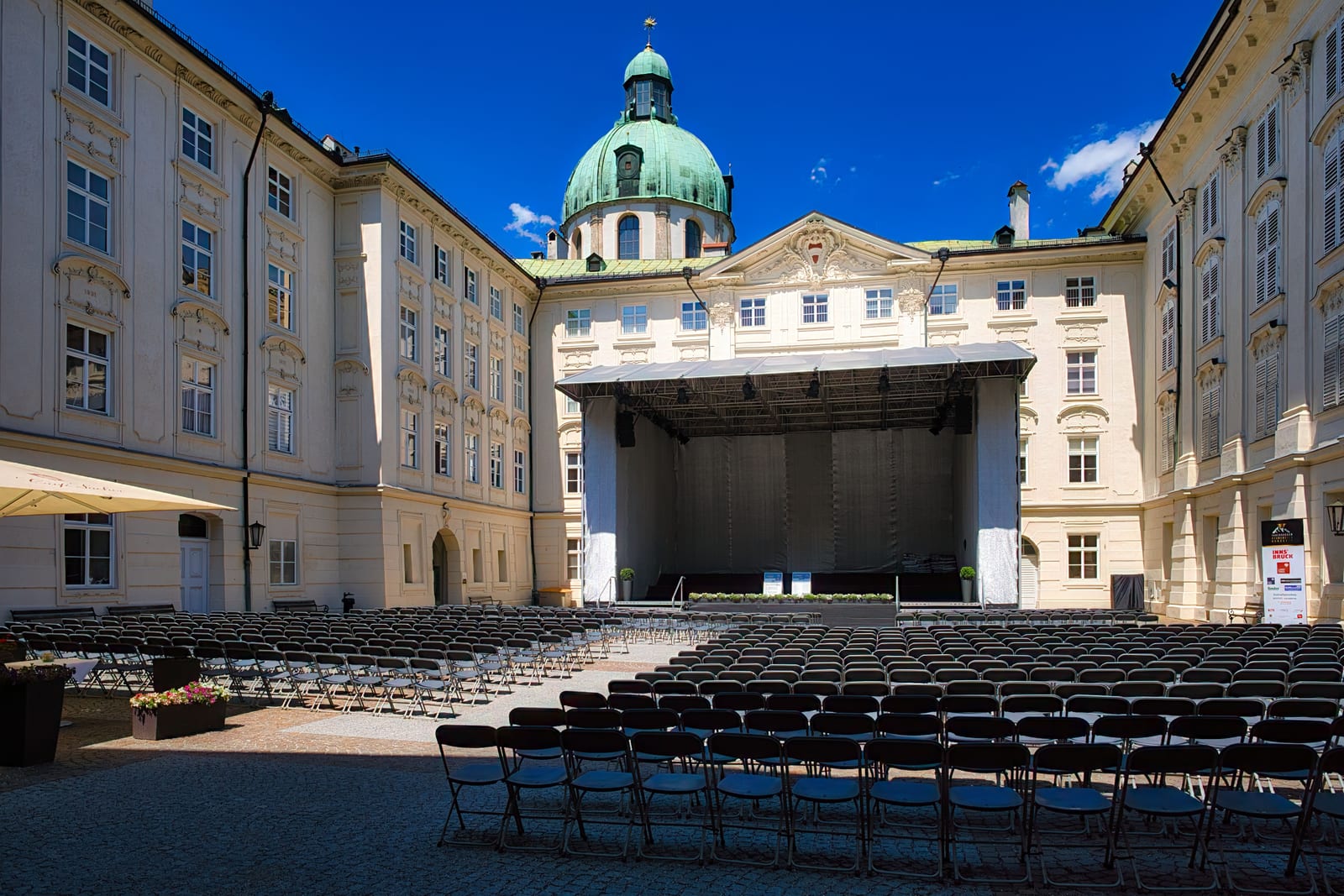 Vom Gerüstbauer errichtete Bühnenkonstruktion in einem Schlosshof vor bestuhltem Publikumsbereich