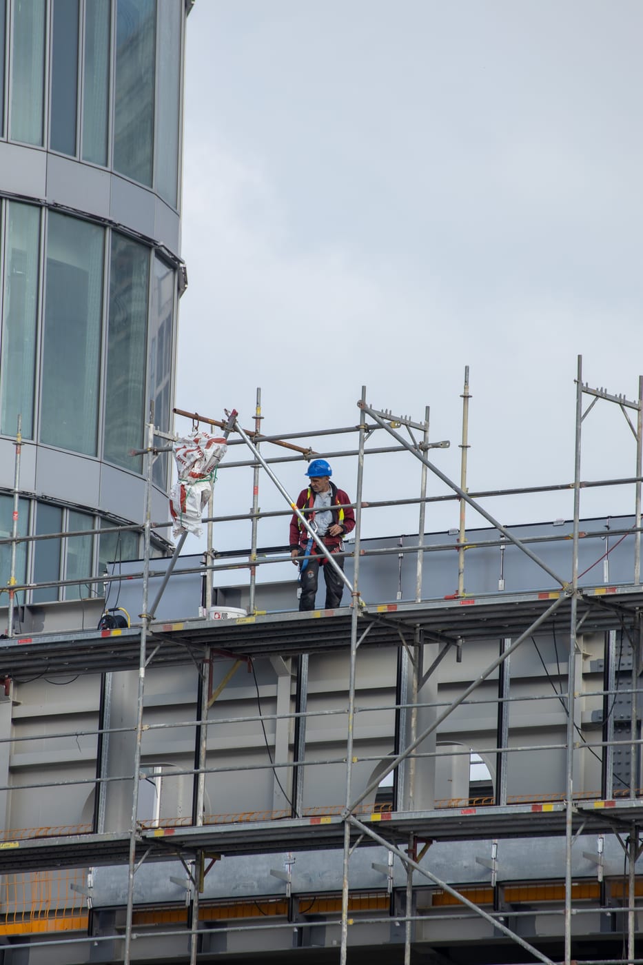 Gerüstbauer kontrolliert eine Arbeitsbühne an einer gerundeten Fassade