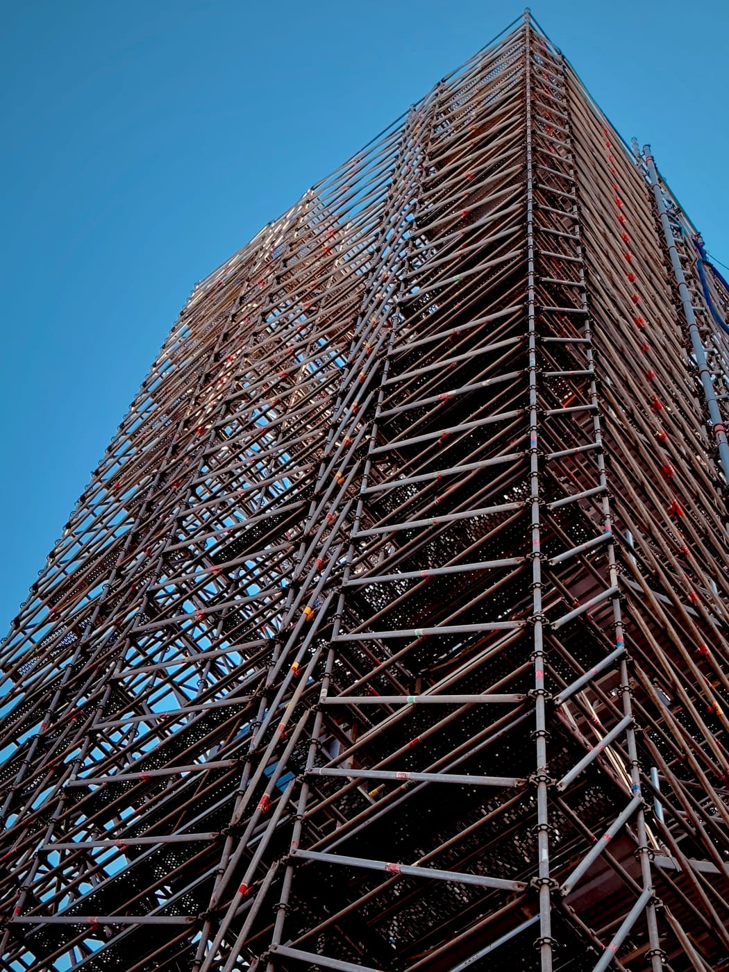 Freistehender Turm des Gerüstbauers aus dicht verstrebten Rahmen, von unten fotografiert