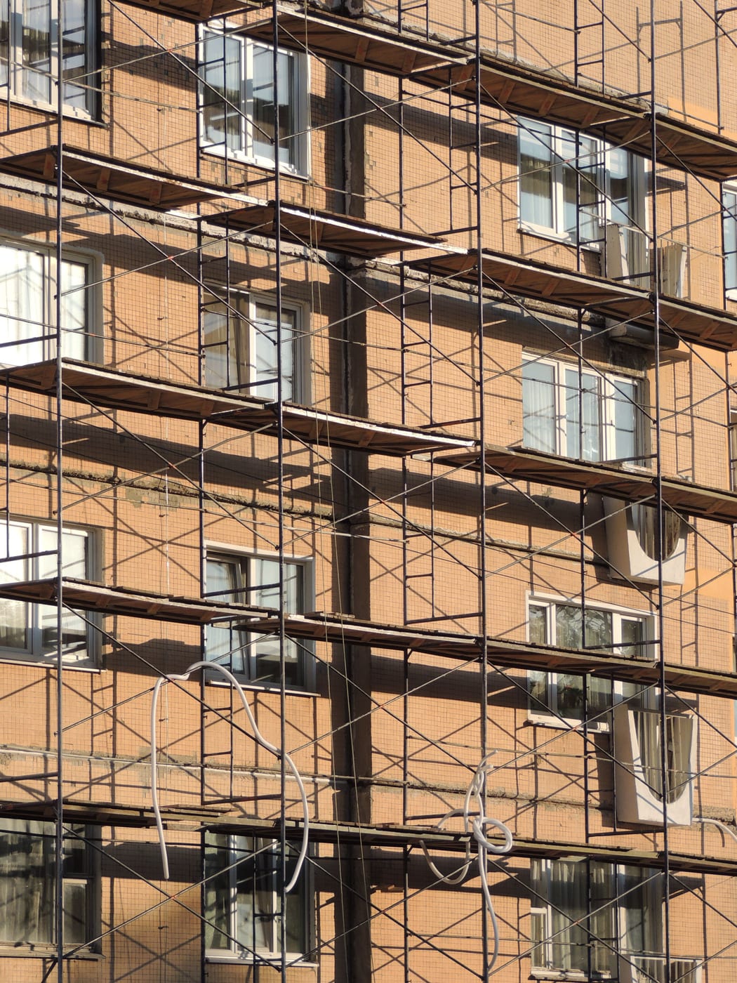 Backsteinfassade mit einem Gerüst des Gerüstbauers über mehrere Fensterreihen